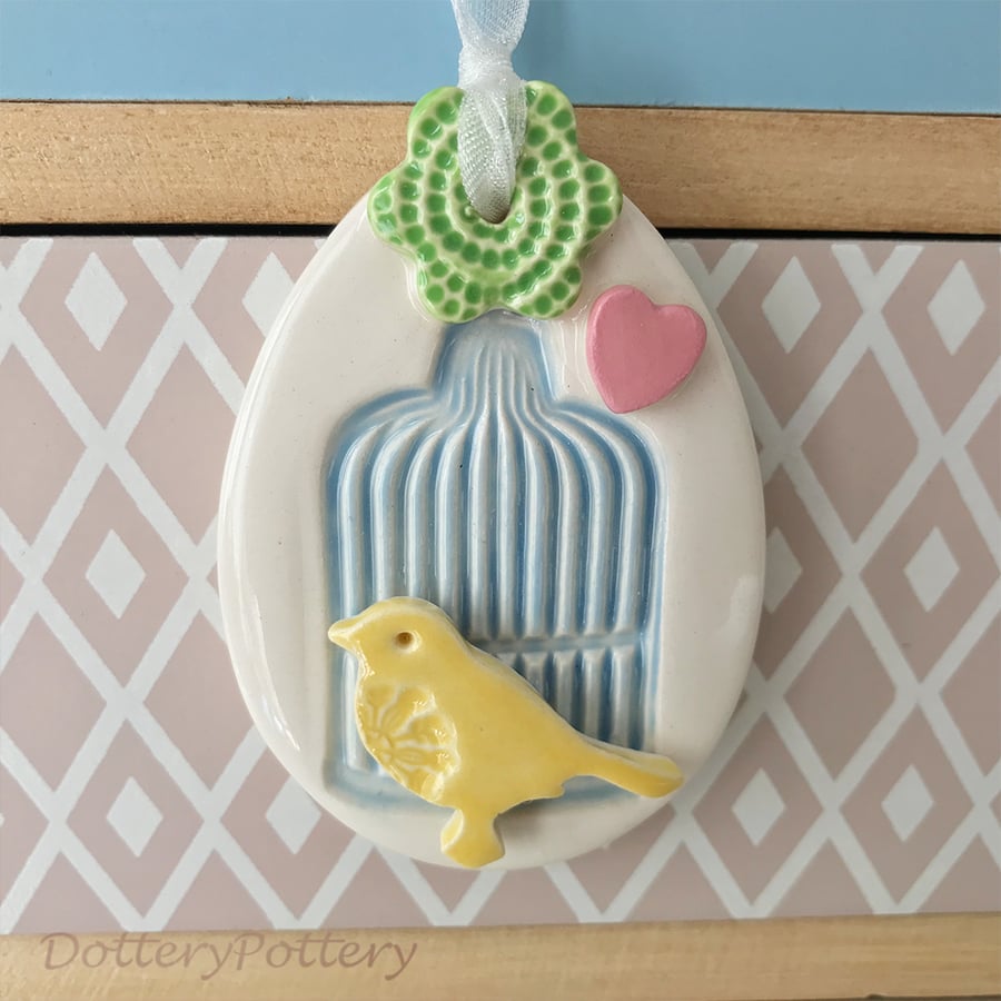 Pottery Easter Egg decoration with blue birdcage yellow bird and flower