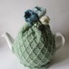 Hand knitted pastel green tea pot cosie with crocus flowers 