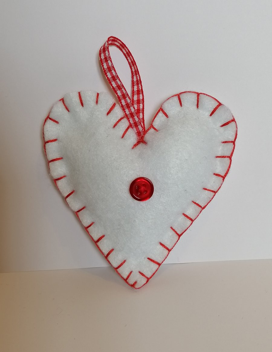 Handmade white felt heart with red stitching, ribbon and button 