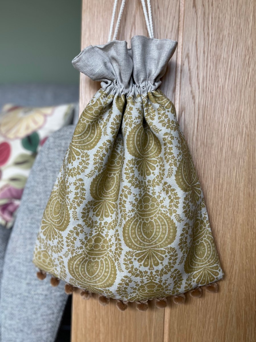 Mustard ochre linen drawstring bag with natural linen lining and pompoms