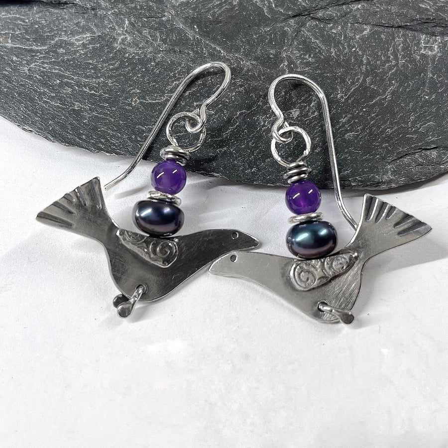 Silver bird earrings with amethyst and black pearl.