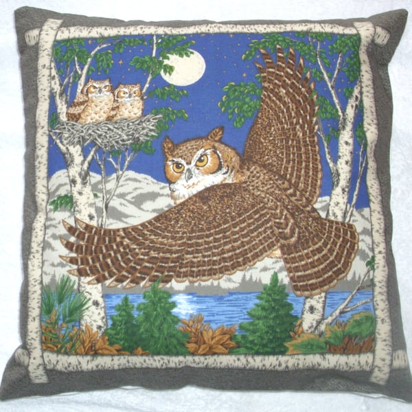 Eagle owl in flight on a moonlit night with two chicks in a nest cushion