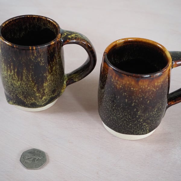 Set of two pottery mugs finished in a multi-colour glaze combination.