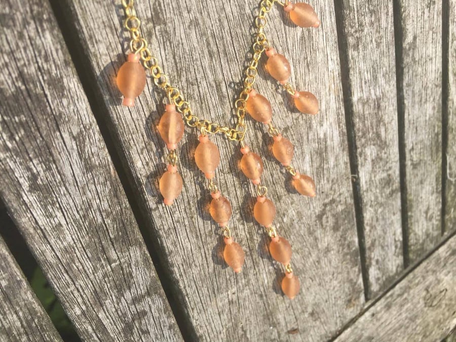 Peach glass beads bib style necklace on gold colour chain