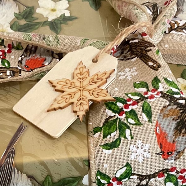 Set of five little wooden Christmas gift tags featuring snowflakes. 