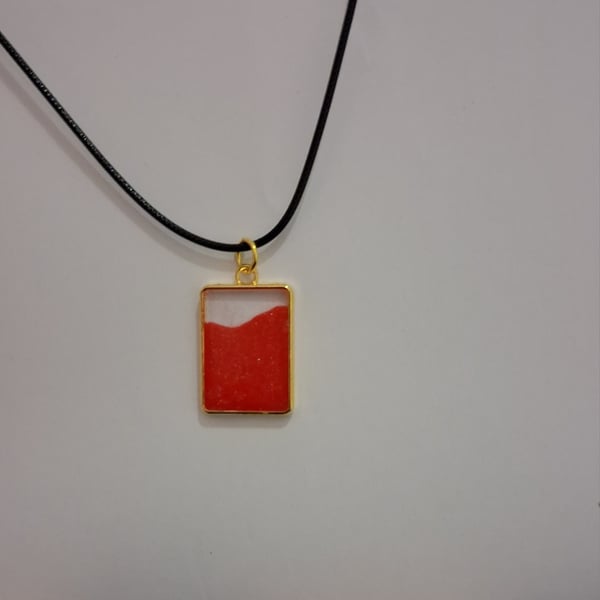 Handmade epoxy resin red and clear rectangular pendant on  black waxed cord