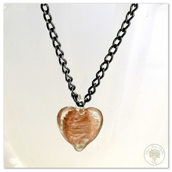 Glass heart pendant with a copper shimmer on black necklace chain