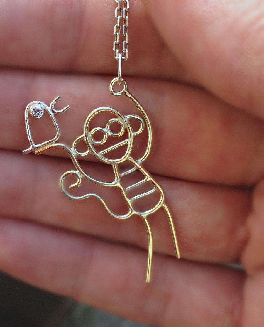 A solid 9ct gold pendant with sterling silver bird designed from childrens art.