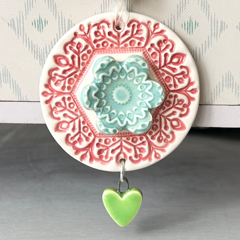 Pottery flower decoration with dangly heart 