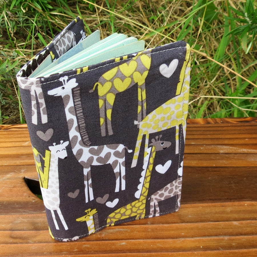A fabric passport sleeve with a whimsical giraffe design. Passport cover.
