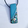 SMALL, SLIM, OBLONG FLORAL ENAMELLED PENDANT WITH STERLING SILVER DESIGN