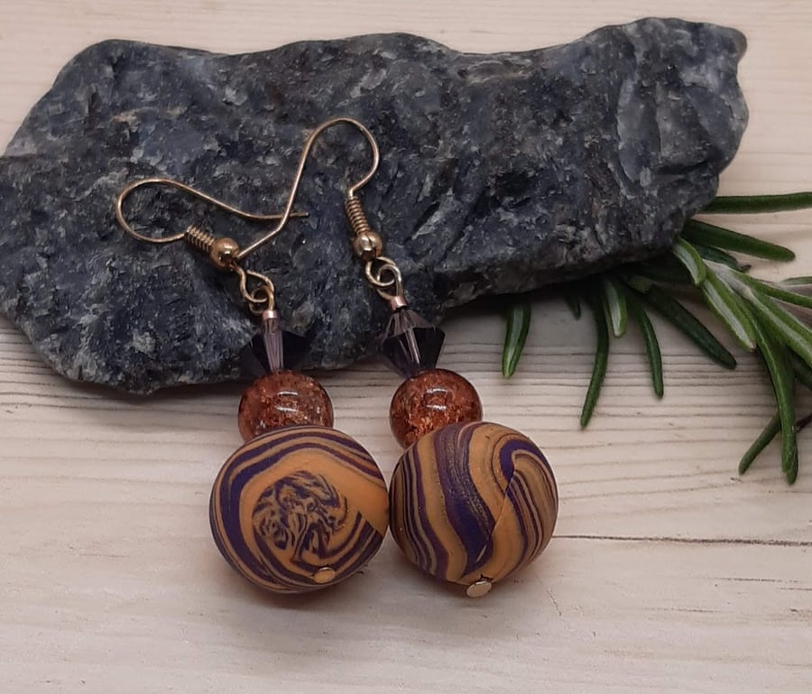 Dangly earrings in purple and gold polymer clay swirl