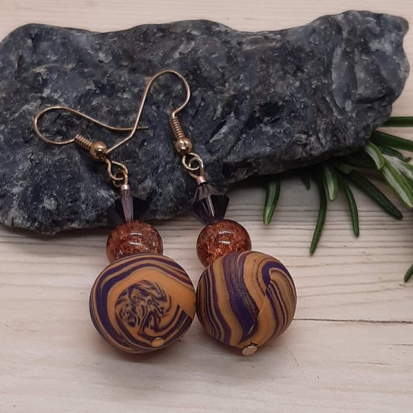 Dangly earrings in purple and gold polymer clay swirl
