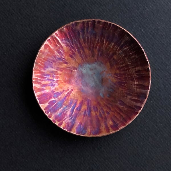 Small flame painted copper bowl with hammered detail.