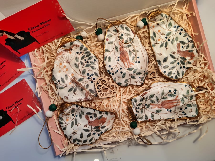 Decoupaged oyster shell ornaments. Winter hares and berries.