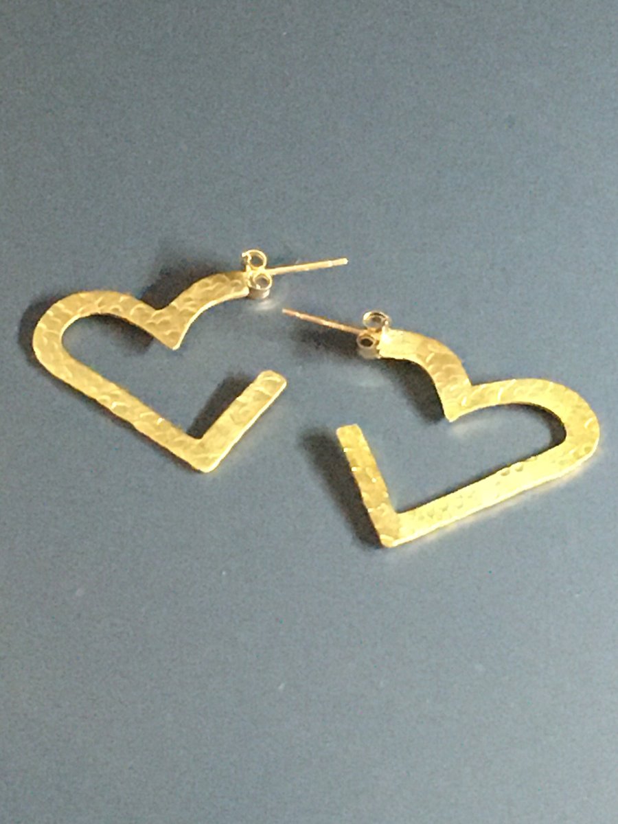 Big hearts are hammered brass heart shaped hoop style earrings