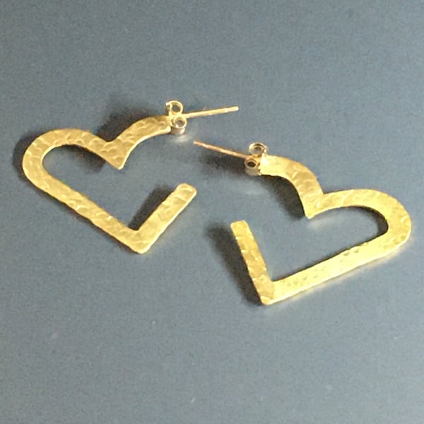 Big hearts are hammered brass heart shaped hoop style earrings