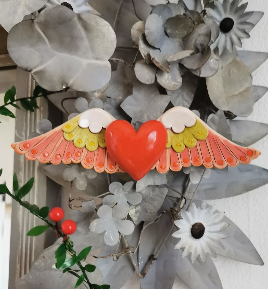 Heart sculpture, red ceramic heart with wings in lime green and pink