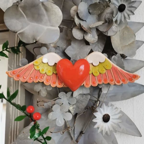 Heart sculpture, red ceramic heart with wings in lime green and pink