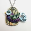 Colourful bird in a cage ceramic pendant