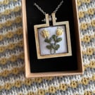Hand embroidered Yellow flowers and set in a wooden necklace.