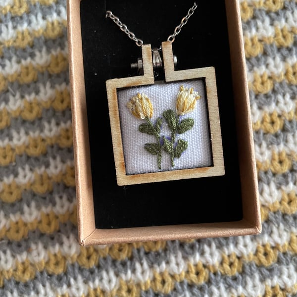 Hand embroidered Yellow flowers and set in a wooden necklace.