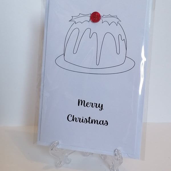 Merry Christmas card with a red button on the top of a Christmas pudding. 