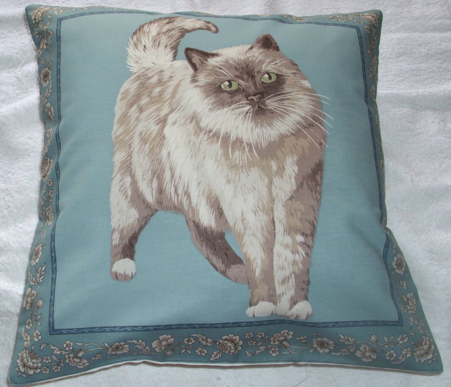 A very pretty grey and white fluffy cat cushion