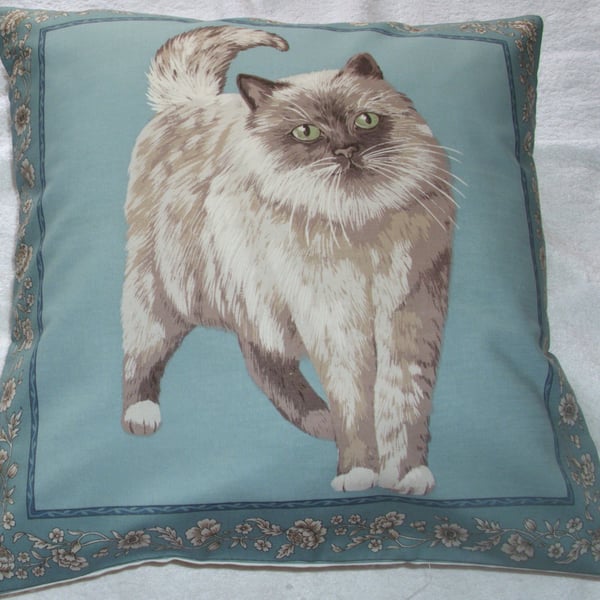 A very pretty grey and white fluffy cat cushion