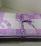 Handmade, quilted cot blanket for the nursery in Lilac patchwork.