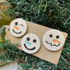 Set of three pottery snowmen magnets on a Christmas gift tag