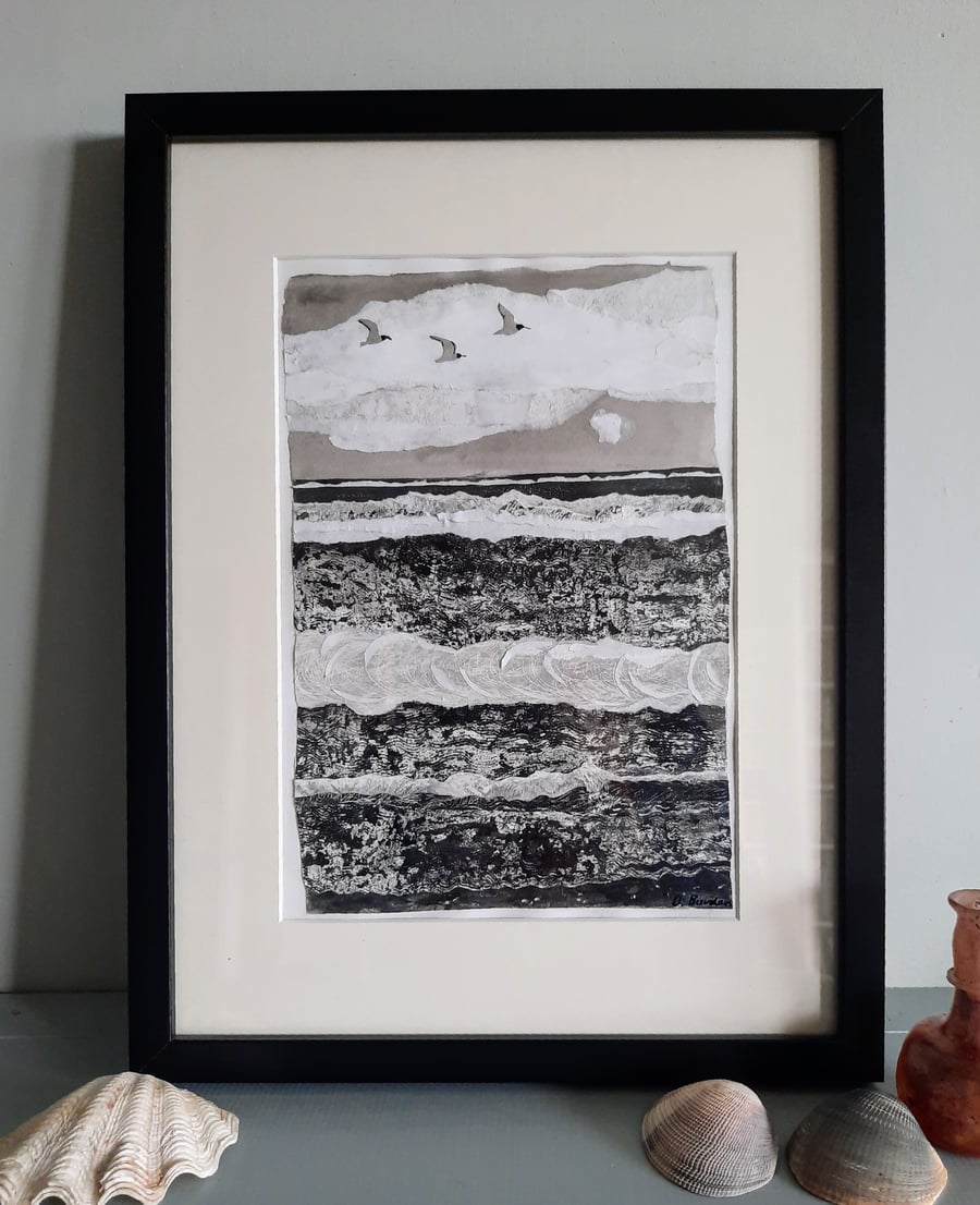 Three birds flying.  Framed black and white collaged seascape.