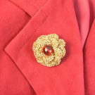 crocheted flower brooch with red glass bead