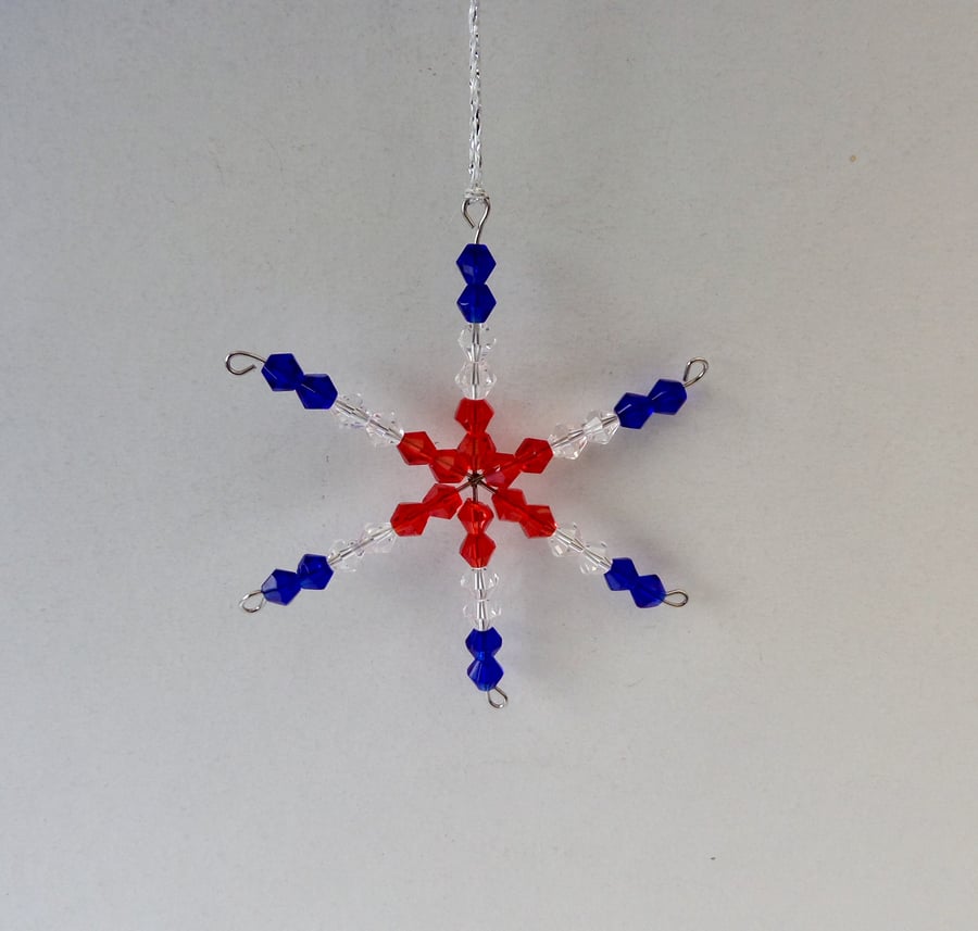 Beaded hanging decoration, red, white (clear) and blue star or snowflake