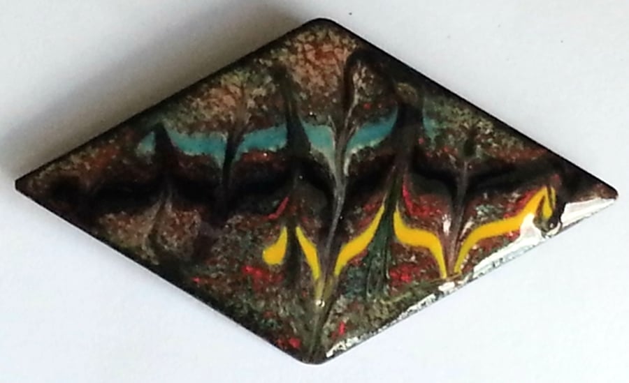 diamond shape - scrolled turquoise, black, yellow over red on clear enamel