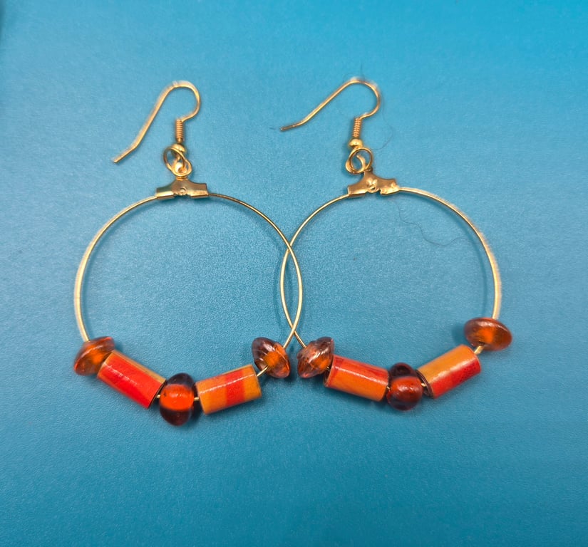Large hoop paper beaded earrings with burnt orange and amber hues