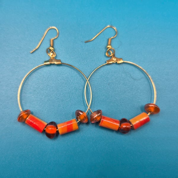 Large hoop paper beaded earrings with burnt orange and amber hues