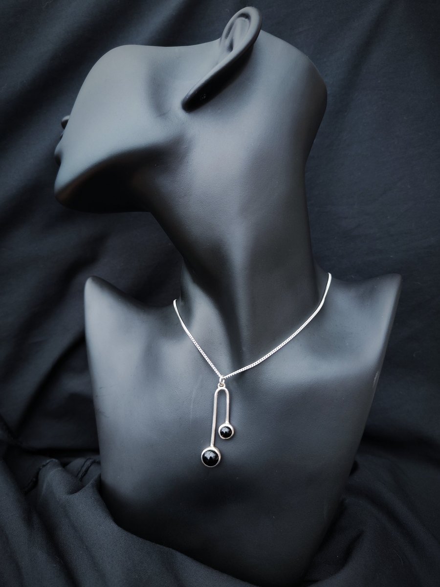 Sterling silver pendant with two black onyx cabochons