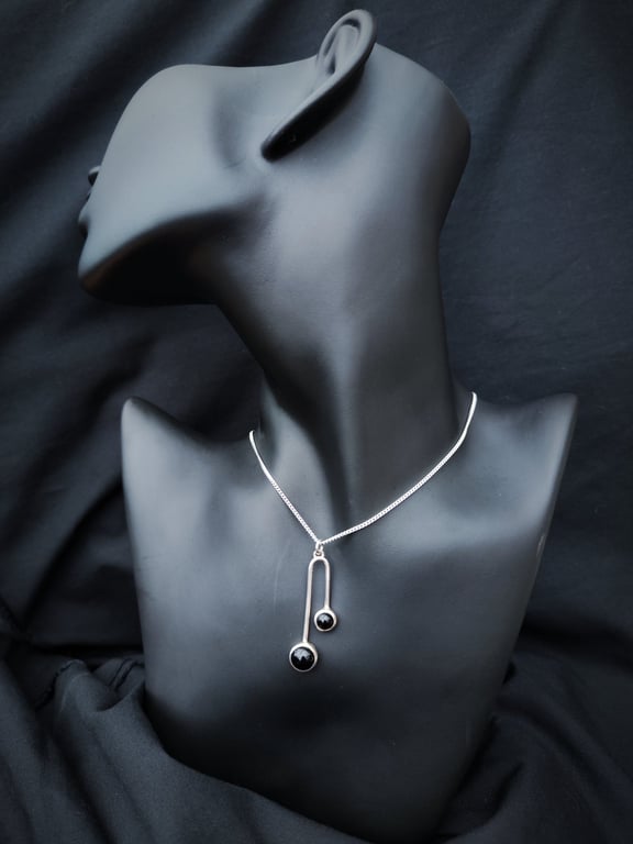 Sterling silver pendant with two black onyx cabochons