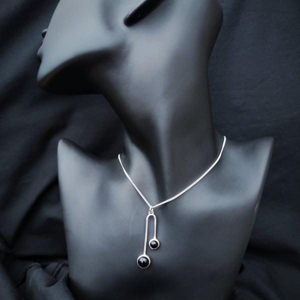 Sterling silver pendant with two black onyx cabochons