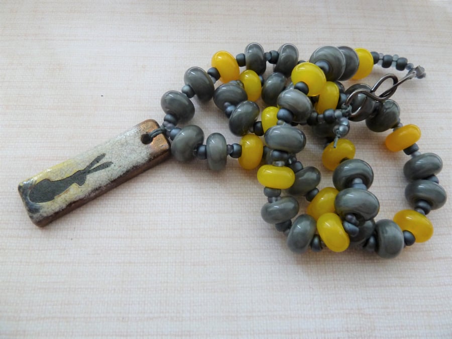 yellow and grey lampwork, copper and ceramic hare necklace