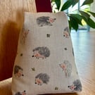 Cotton rich fabric doorstop in taupe, with hedgehogs design, filled with pebbles