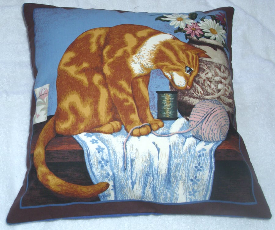 A lovely Ginger and white cat sitting with a vase of flowers cushion