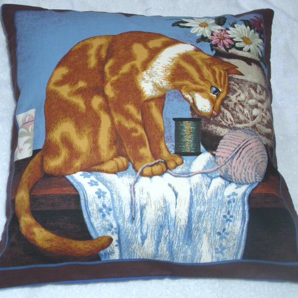 A lovely Ginger and white cat sitting with a vase of flowers cushion