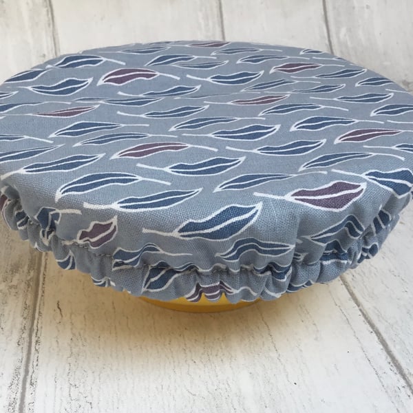 One small reusable bowl cover to fit a cereal-sized bowl. Blue leaves