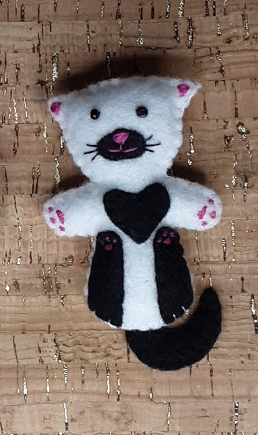 Cat on back White Felt Brooch with black legs, tail, chest & muzzle.