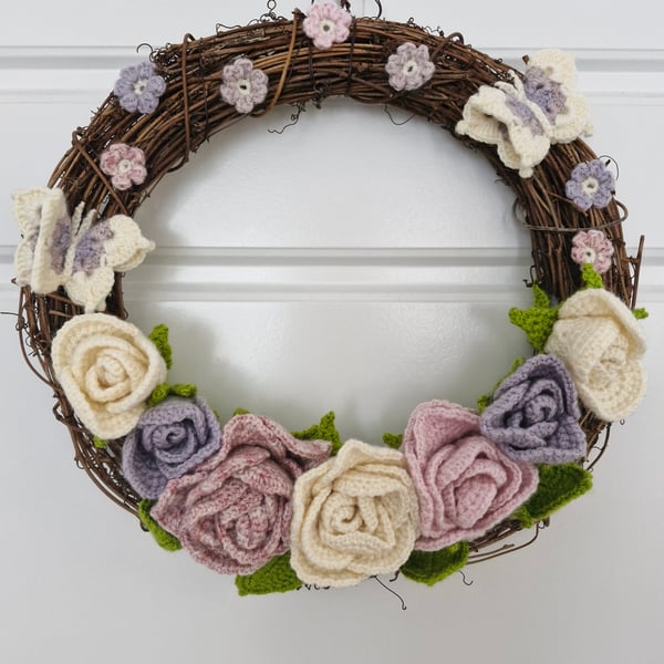 Crocheted pastel roses, butterflies and delicate cherry blossom flowers wreath.