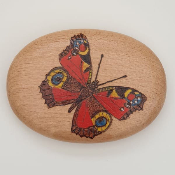 Pyrography peacock butterfly decorated wooden pebble, British wildlife gift