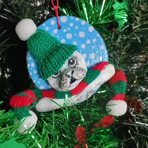 Christmas tree decoration of a Seal, airdry clay with a fabric hat and scarf.  
