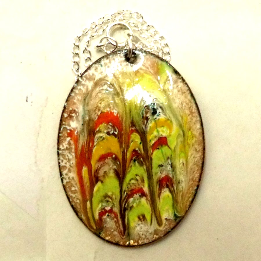 oval pendant - scrolled red, green, brown, orange on white enamel over clear